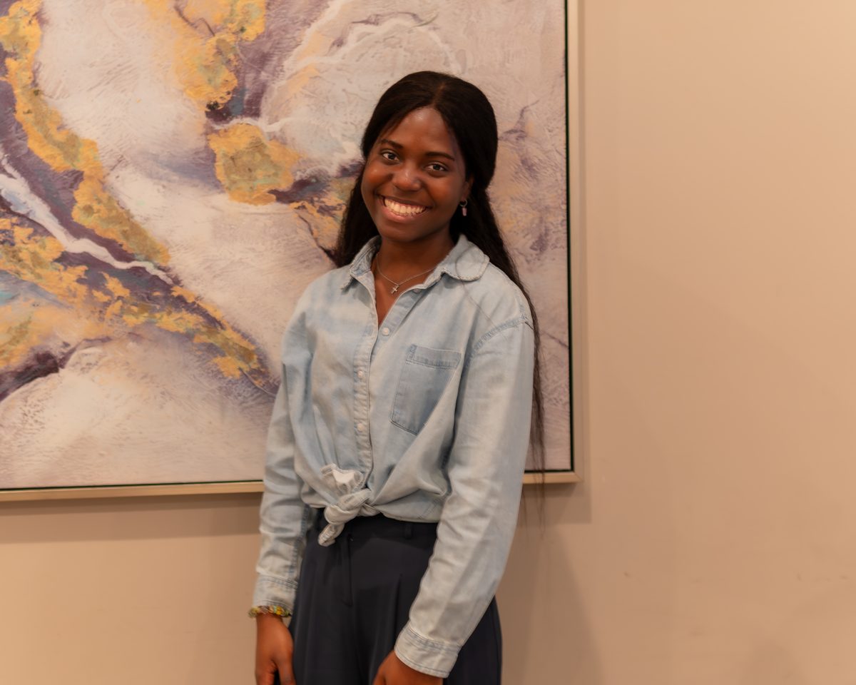 Smiling woman standing by artwork